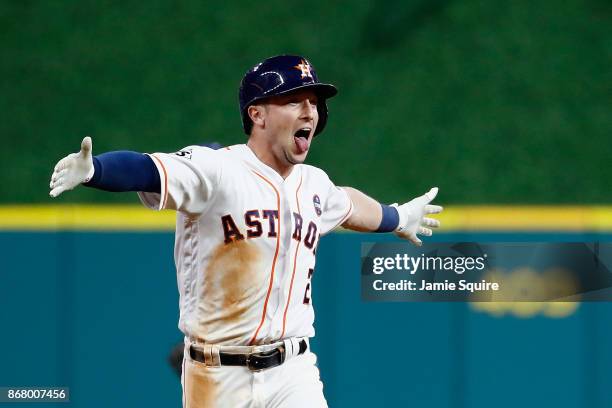 Alex Bregman of the Houston Astros celebrates after hitting a game-winning single during the tenth inning against the Los Angeles Dodgers in game...