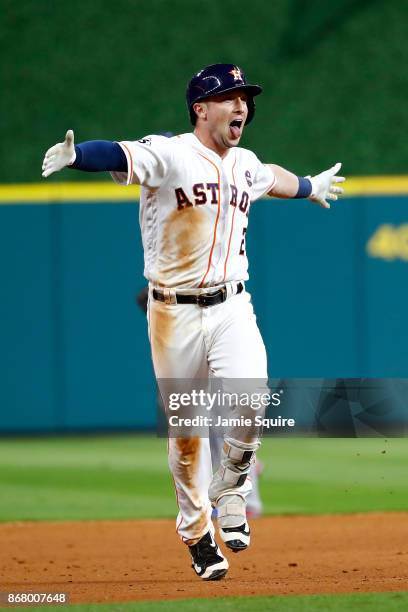 Alex Bregman of the Houston Astros celebrates after hitting a game-winning single during the tenth inning against the Los Angeles Dodgers in game...