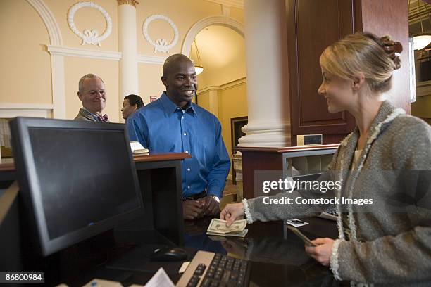 man waiting in line for bank teller - teller stock pictures, royalty-free photos & images