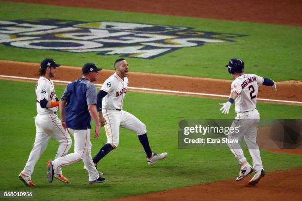 Alex Bregman of the Houston Astros celebrates with teammates after hitting a game-winning single during the tenth inning against the Los Angeles...