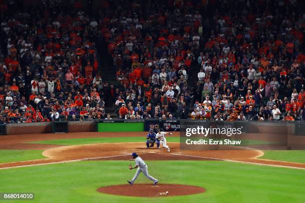 Alex Bregman of the Houston Astros hits a game-winning single during the tenth inning against Kenley Jansen of the Los Angeles Dodgers in game five...