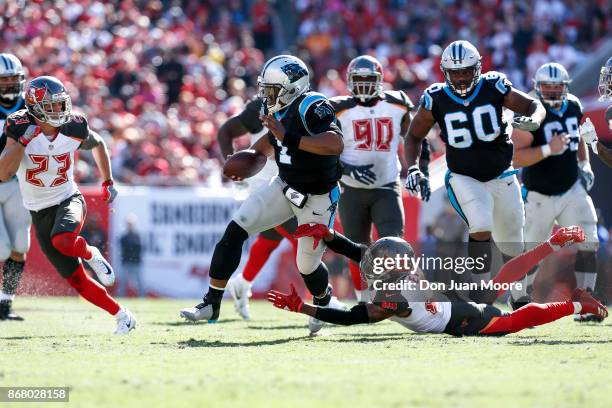 Quarterback Cam Newton of the Carolina Panthers on a running play avoids being tackled by Safeties Justin Evans and Chris Conte of the Tampa Bay...