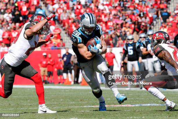 Runningback Christian McCattrey of the Carolina Panthers avoids a tackle from Safety Chris Conte and Cornerback Justin Evans of the Tampa Bay...