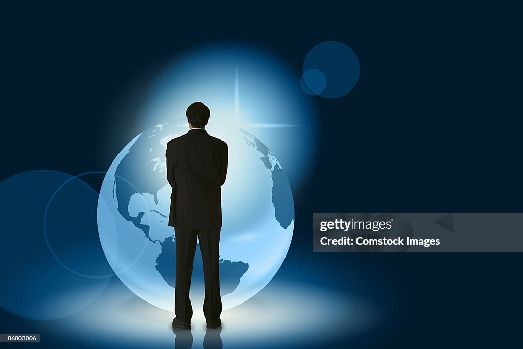 Businessman standing near globe