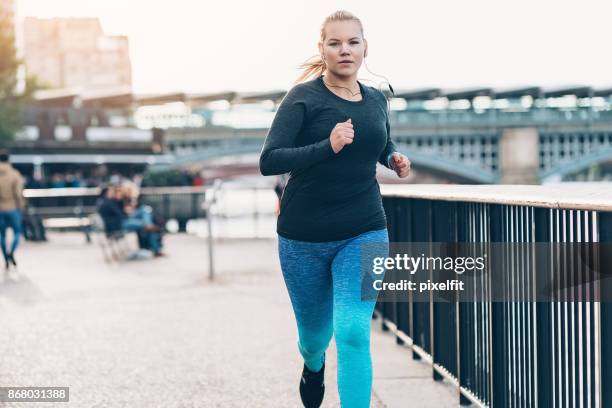 jonge vrouw joggen in de ochtend - voluptueus stockfoto's en -beelden