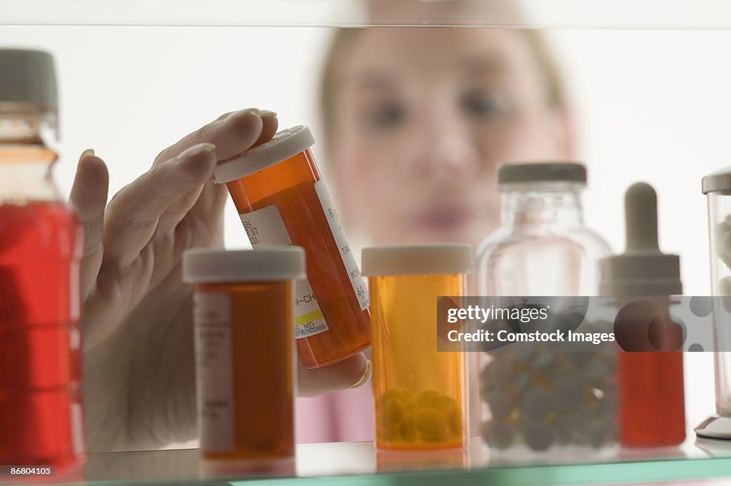 Person grabbing bottle of medicine