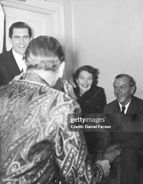 English novelist and playwright Graham Greene and his mistress Catherine Walston pay a visit to Noel Coward , who is starring in Michael MacOwan's...