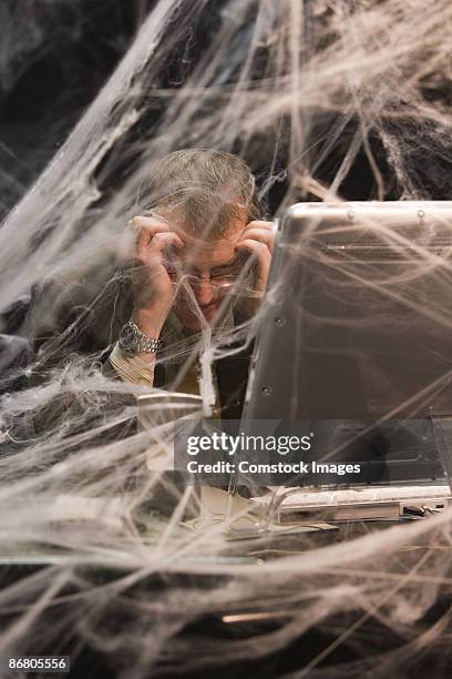 man sitting at desk covered in cobwebs - trapped in the web stock pictures, royalty-free photos & images