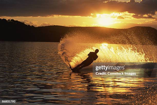 silhouette of person waterskiing - waterskiing stock pictures, royalty-free photos & images