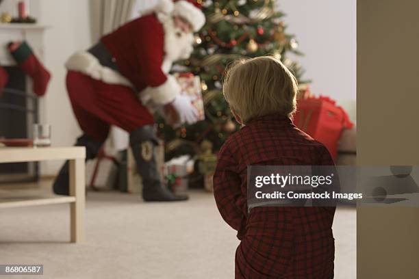 child peeking at santa claus - santa claus lying stockfoto's en -beelden