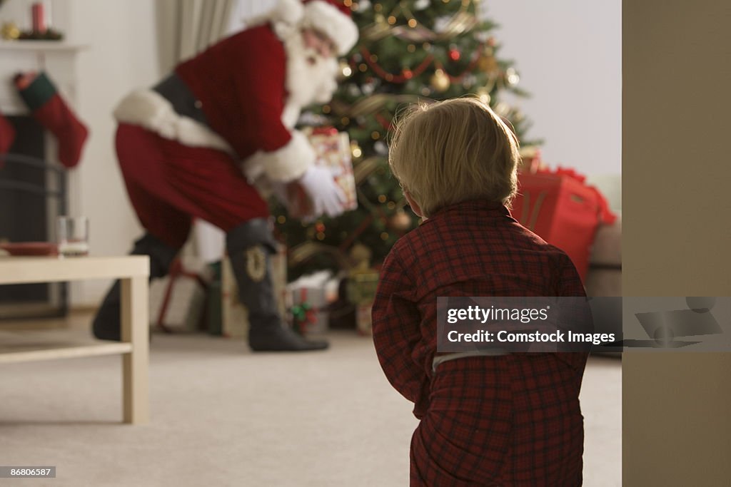 Child peeking at santa claus