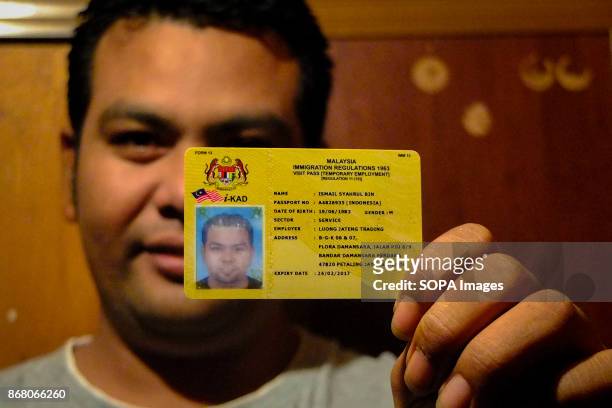 Syahrul holding his visa and working permit proudly. He first arrived to Malaysia illegaly and after he made a sufficient money then he made all the...