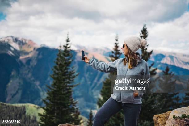 pregnant woman taking photos with smartphone in the mountains - european best pictures of the day september 25 2017 stock pictures, royalty-free photos & images