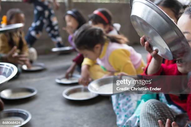 Kalimpong, India Several school children are sitting on the ground to eat rice from metal plates on February 24, 2013 in Kalimpong, India