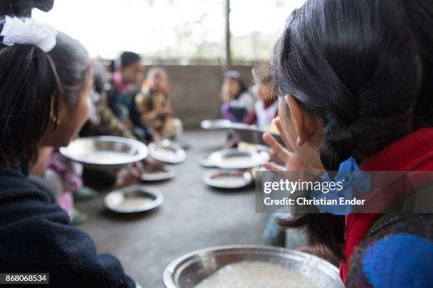 Kalimpong, India Several school children are sitting on the ground to eat rice from metal plates on February 24, 2013 in Kalimpong, India