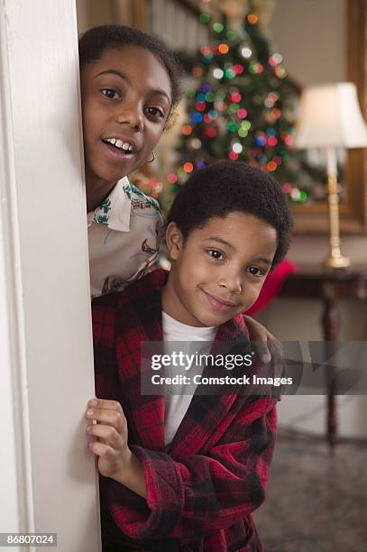 children peeking at christmas - gluren stockfoto's en -beelden