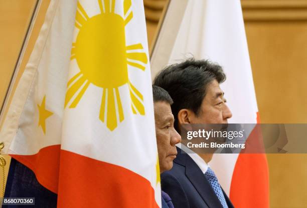 Rodrigo Duterte, the Philippines' president, left, and Shinzo Abe, Japan's prime minister, review an honor guard during a welcoming ceremony in...