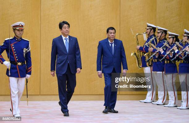 Rodrigo Duterte, the Philippines' president, right, and Shinzo Abe, Japan's prime minister, walk past an honor guard during a welcoming ceremony in...