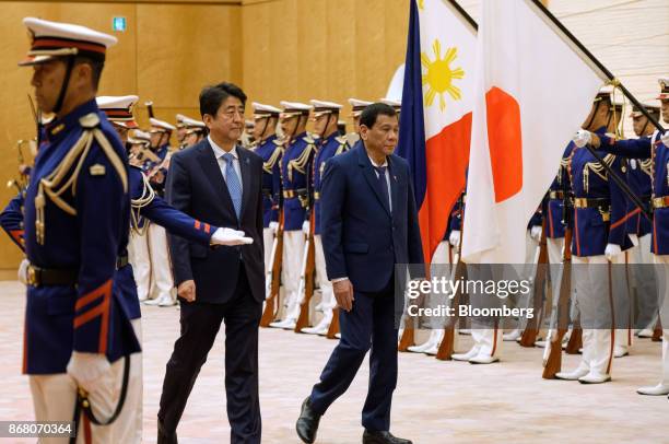 Rodrigo Duterte, the Philippines' president, right, and Shinzo Abe, Japan's prime minister, walk past an honor guard during a welcoming ceremony in...