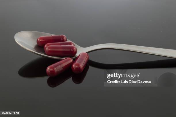 spoonful of capsules - snorted stock pictures, royalty-free photos & images