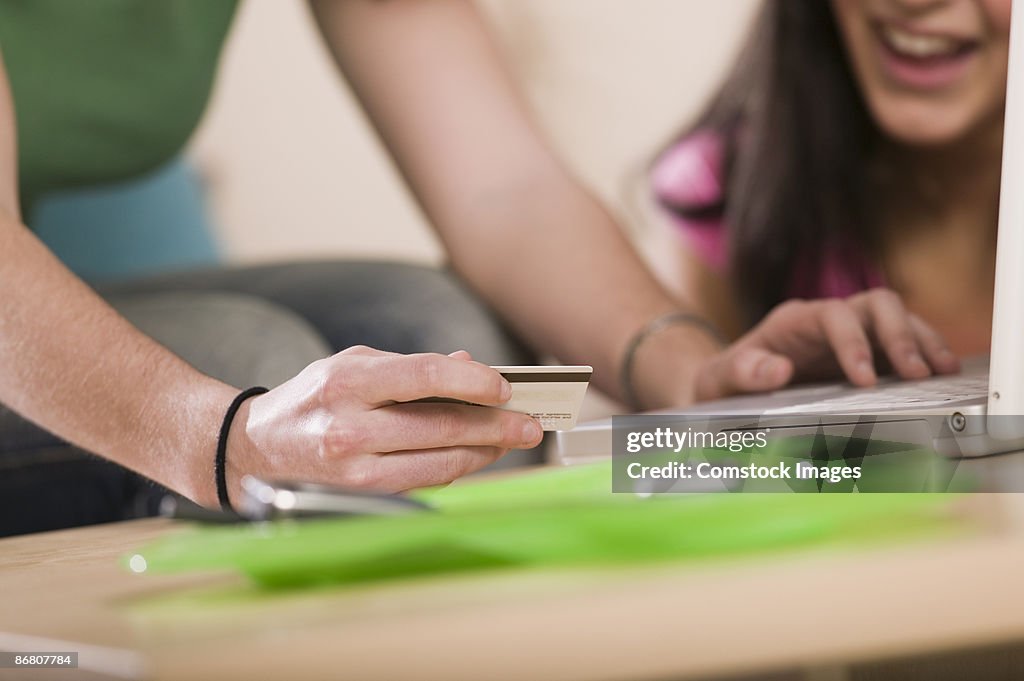 Two people with a credit card and computer