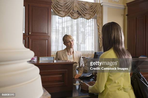 woman at bank counter conversing with teller - bank teller and customer stock-fotos und bilder