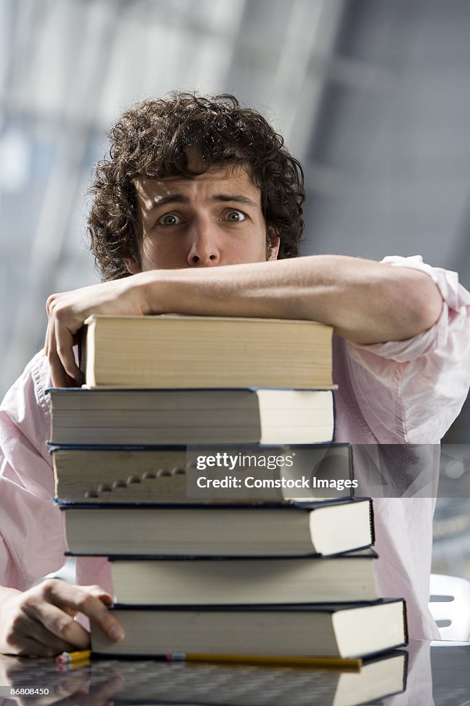 Man looking worried on a stack of books
