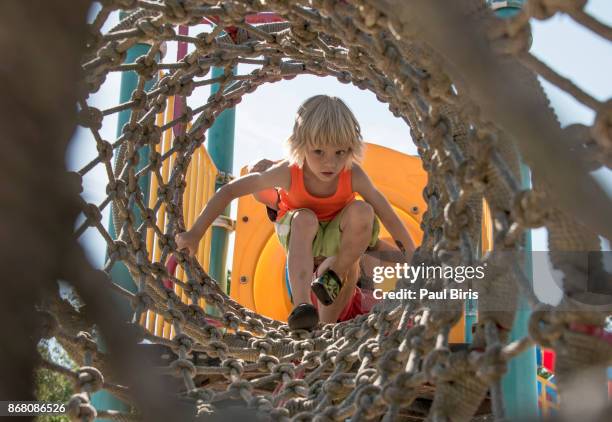 little boy in amusement park rope tunnel - adrenaline park stock pictures, royalty-free photos & images