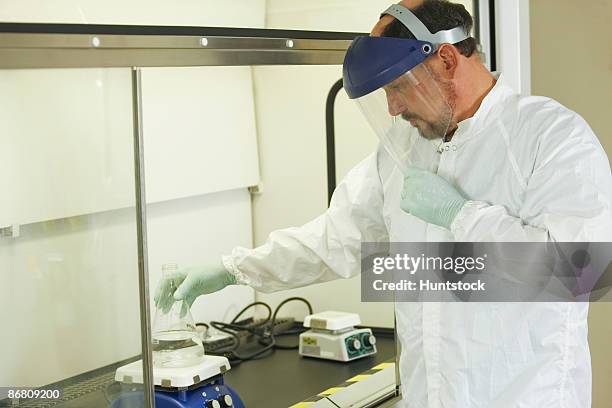 scientist standing at a fume hood with face shield - face shield 個照片及圖片檔