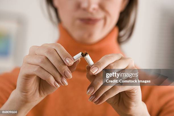 woman breaking cigarette - breaking habits ストックフォトと画像
