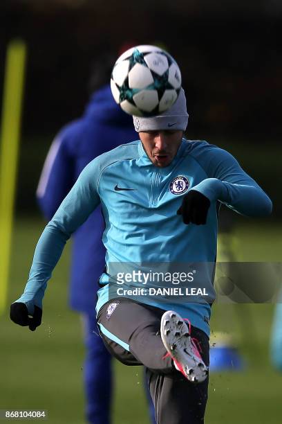 Chelsea's Belgian midfielder Eden Hazard heads a ball at a training session at Chelsea's Cobham training facility in Stoke D'Abernon, southwest of...