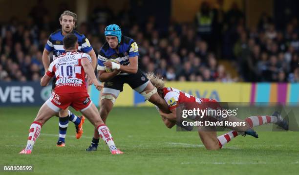 Zach Mercer of Bath is held by Richard Hibbard during the Aviva Premiership match between Bath Rugby and Gloucester Rugby at the Recreation Ground on...