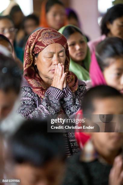 Kalimpong, India A woman wearing a sari is praying with closed eyes while a ceremony inside a church in Kalimpong.