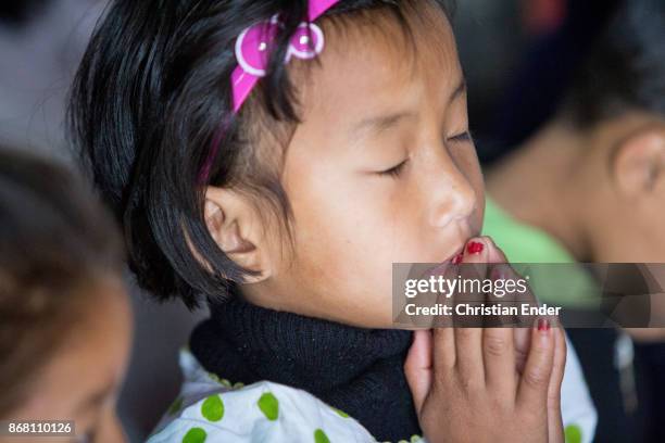 Kalimpong, India A young girl is praying with her eyes closed while a ceremony inside a church in Kalimpong.