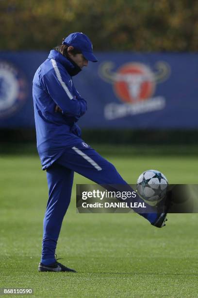 Chelsea's Italian head coach Antonio Conte plays with a football at a training session at Chelsea's Cobham training facility in Stoke D'Abernon,...