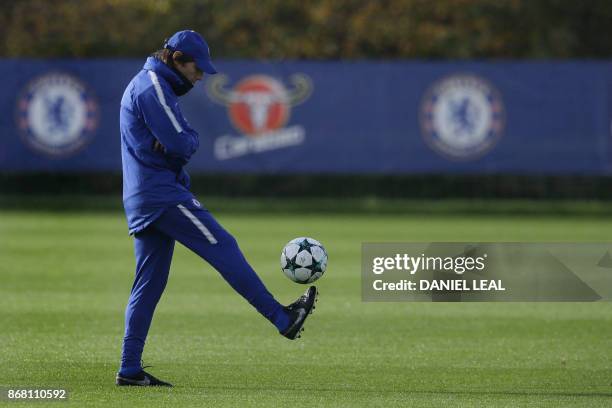 Chelsea's Italian head coach Antonio Conte plays with a football at a training session at Chelsea's Cobham training facility in Stoke D'Abernon,...