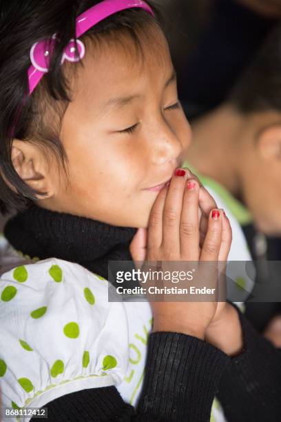 Kalimpong, India A young girl is praying with her eyes closed while a ceremony inside a church in Kalimpong.