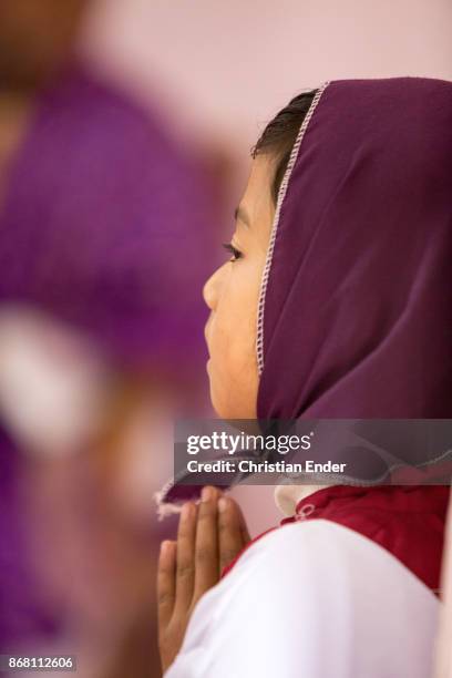 Kalimpong, India A young girl as a altar server with a tunicle is praying inside a church in Kalimpong.