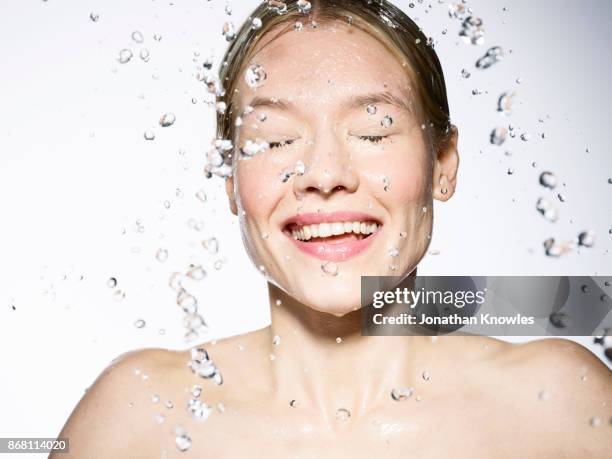 young caucasian female with water splashes - wet face stock pictures, royalty-free photos & images