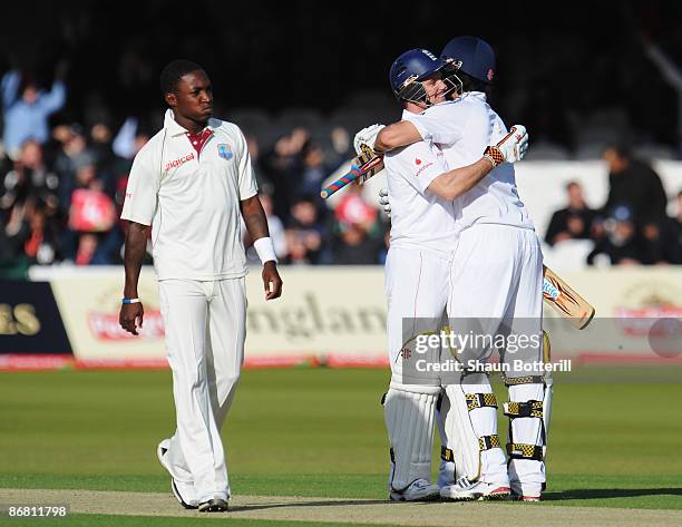 Andrew Strauss and Alastair Cook of England celebrate victory as Fidel Edwards of West Indies looks on after day three of the 1st npower Test match...