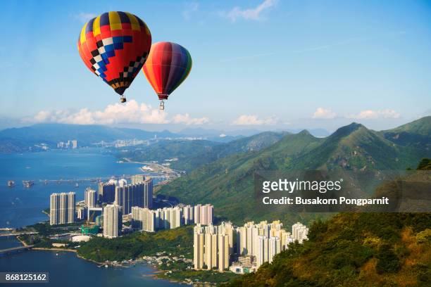 hot air balloon over hill and sea with beautiful mountain view in hong kong - hot air balloon ride stock pictures, royalty-free photos & images