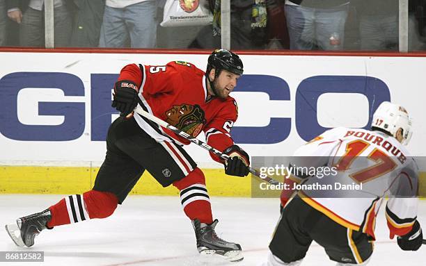 Cam Barker of the Chicago Blackhawks shoots against Rene Bourque of the Calgary Flames during Game Five of the Western Conference Quarterfinals of...