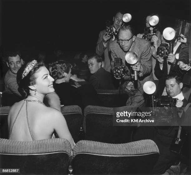 American actress Ava Gardner smiles for photographers, while sitting in a theater for the premiere of director Joseph L Mankiewicz's film, 'The...