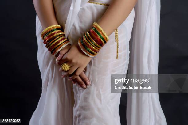 arms of an indian woman wearing bangles. - woman in red sari stock pictures, royalty-free photos & images