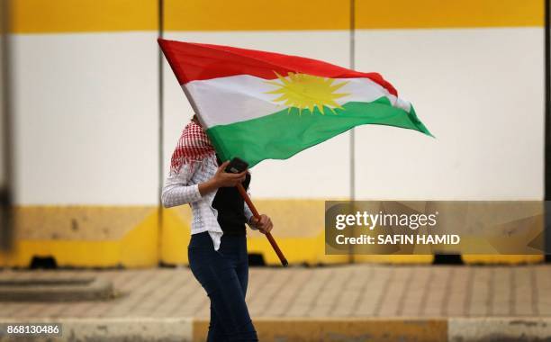 An Iraqi Kurd marches with a Kurdish flag during a protest in support of the Iraqi Kurdish leader, in Arbil, the capital of autonomous Iraqi...