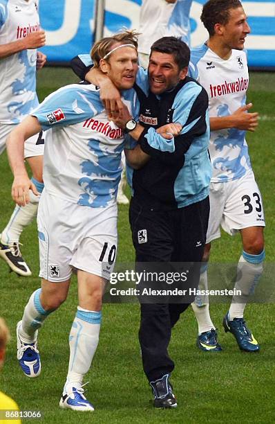 Sascha Roessler of Muenchen celebrates with his head coach Uwe Wolf scoring the 3rd goal for his team during the Second Bundesliga match between TSV...