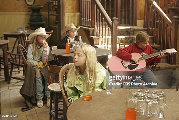 As Emilie plays her guitar, Leila relaxes as Randi and Sophie enjoy their refreshments in KID NATION on the CBS Television Network.