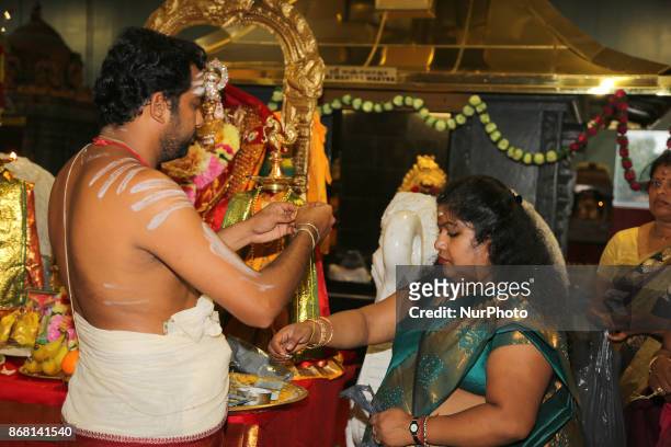 Tamil Hindu priest blesses women participating in special prayers during Varalaxmi Pooja at a Tamil Hindu temple in Toronto, Ontario, Canada....
