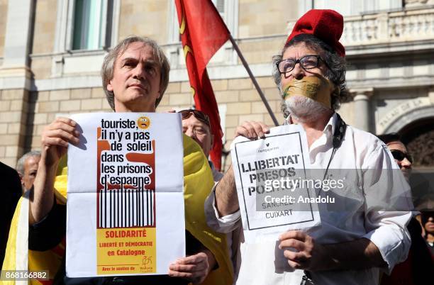 Demonstrator with his mouth duck taped holds a banner in front of the 'Generalitat' palace in Barcelona on October 30, 2017. Spain enters uncharted...