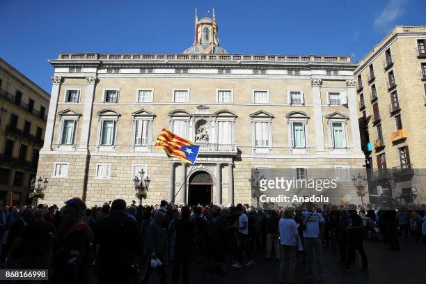 Catalan independence supporter flies a Catalan Estelada flag in front of the 'Generalitat' palace in Barcelona on October 30, 2017. Spain enters...